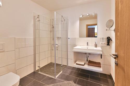 uma casa de banho com um chuveiro e um lavatório. em Haus Flexen em Stuben am Arlberg