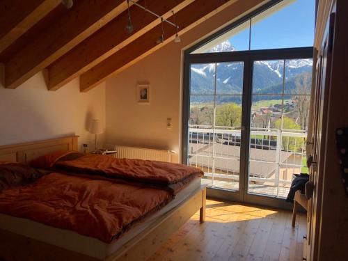 - une chambre avec un lit et une grande fenêtre dans l'établissement Panoramablick, à Lermoos