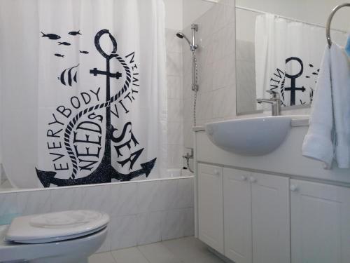 a bathroom with a toilet and a sink and a shower curtain at Kings Palace Indigo 109 in Paphos