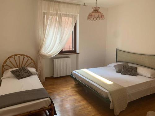 a bedroom with two beds and a window at Il Portico 9 in Bussolengo
