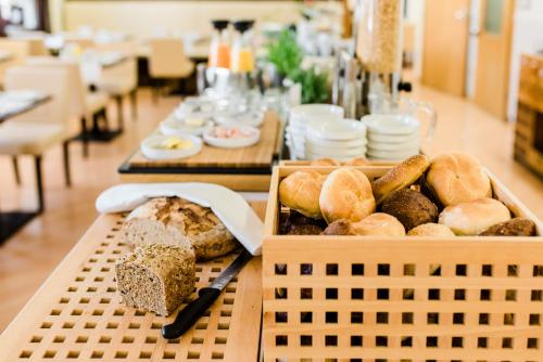 a long table with bread and pastries on it at Hotel Weidenhof in Regensburg
