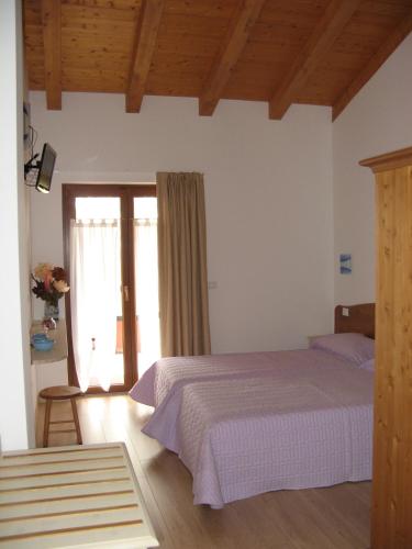 a bedroom with a bed and a sliding glass door at Bosco Romagno in Cividale del Friuli