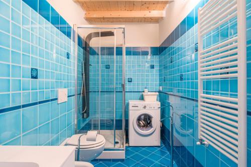 レヴァントにあるLe 3 Sireneの青いタイル張りのバスルーム(洗濯機付)