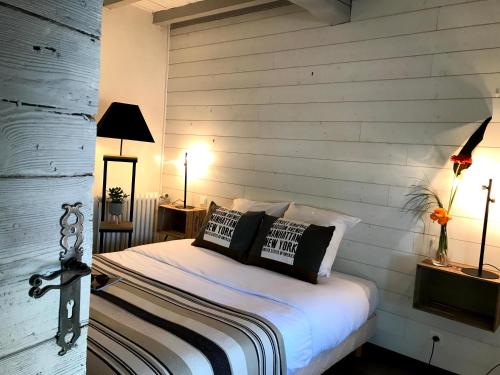 1 dormitorio con 1 cama con pared de madera en HOSTELLERIE DES BICHONNIERES, en Ambérieux-en-Dombes