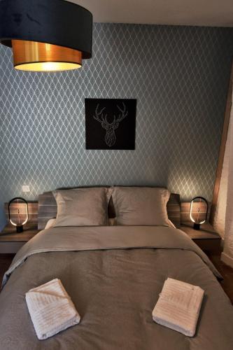 une chambre avec un lit avec deux serviettes dessus dans l'établissement Le Petit Porte Guillaume, à Chartres