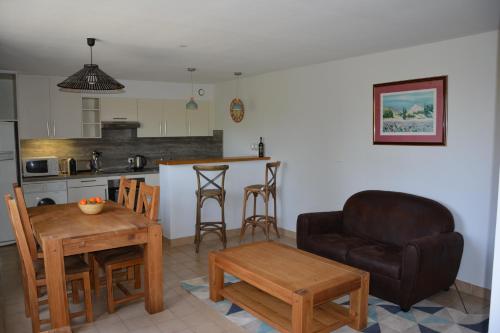 a kitchen and living room with a couch and a table at La Ferme du Cayla in Linac