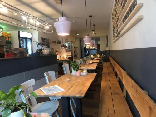 - une rangée de tables et de chaises en bois dans un restaurant dans l'établissement Milk and cookies, à Venlo