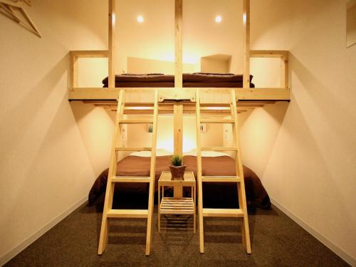 two bunk beds in a small room with a plant at Osaka Guesthouse Nest in Osaka
