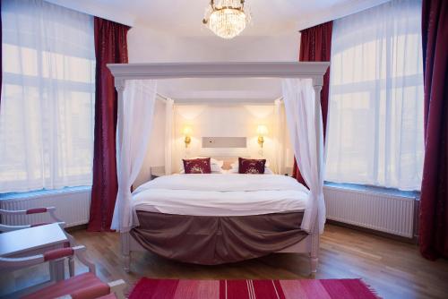 a bedroom with a canopy bed with red curtains at Brommavik Hotel in Stockholm