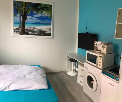 een slaapkamer met een bed en een wasmachine bij Moderne und gemütliches Appartement im EG mit eigenem Zugang in guter Wohnlage in Mülheim an der Ruhr