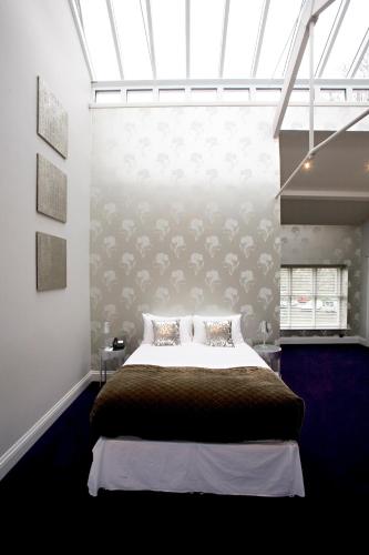 a bedroom with a large bed with a large window at Aston Hall Hotel, BW Signature Collection in Sheffield