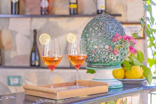two glasses of wine on a table with a vase at CVM Montagnella Relax in Maiori