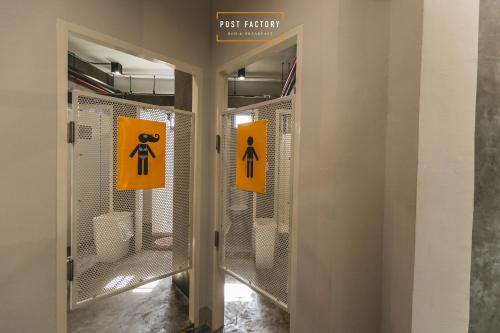 a bathroom with two doors with signs on them at Post Factory Bed & Breakfast in Bangkok