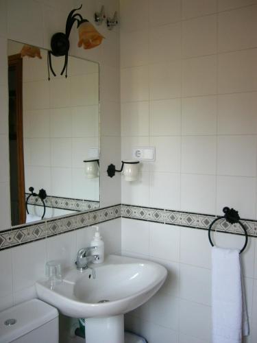a white bathroom with a sink and a mirror at Hostal Calderon Cuenca in Cuenca
