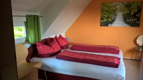 a bedroom with two beds with red pillows at Ferienhaus Fernblick Altenberg in Kurort Altenberg