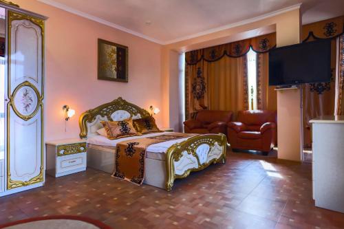 ein Schlafzimmer mit einem Bett, einem Sofa und einem TV in der Unterkunft SM Royal Hotel - ALL INCLUSIVE in Adler
