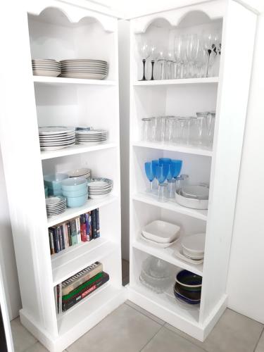 a white pantry with plates and dishes in it at Lieflappie❤ in Stilbaai