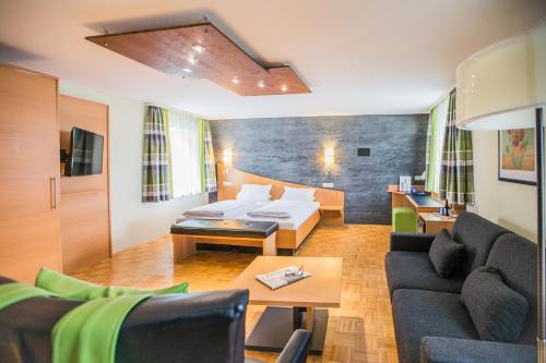 sala de estar con cama y sofá en Hotel Am Turm, en Kaufbeuren