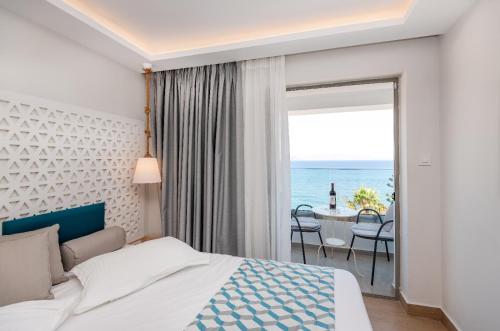 a bedroom with a bed and a view of the ocean at Triton Boutique Hotel in Kos Town