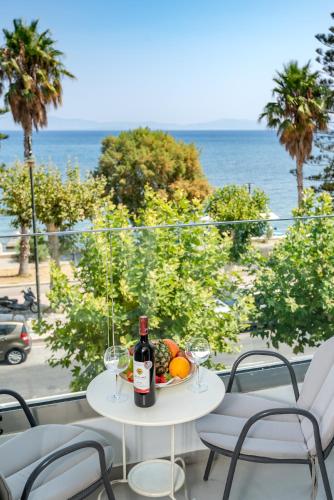 a table with a bottle of wine and a bowl of fruit at Triton Boutique Hotel in Kos Town