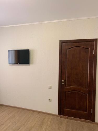 a room with a door and a television on a wall at Apartment on Pastukhova 31 in Pyatigorsk