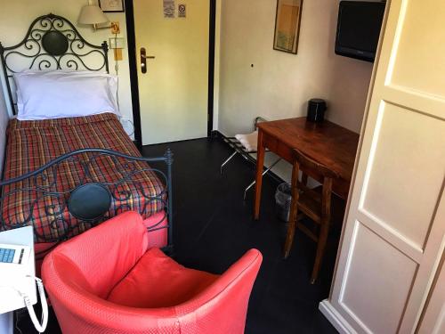a bedroom with a bed and a desk and a chair at Hotel Beau Rivage in Alassio