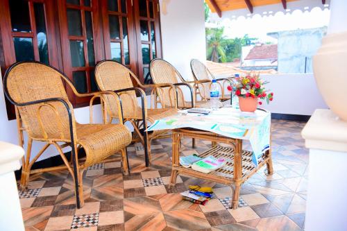 um grupo de cadeiras e uma mesa com flores em Joseph Family Villa em Negombo