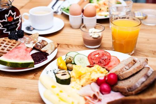 two plates of breakfast food on a wooden table at Apart Neptun in Gdańsk