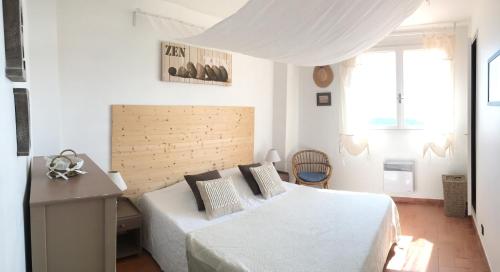 a white bedroom with a bed and a desk at La Villa Cavalaire in Cavalaire-sur-Mer