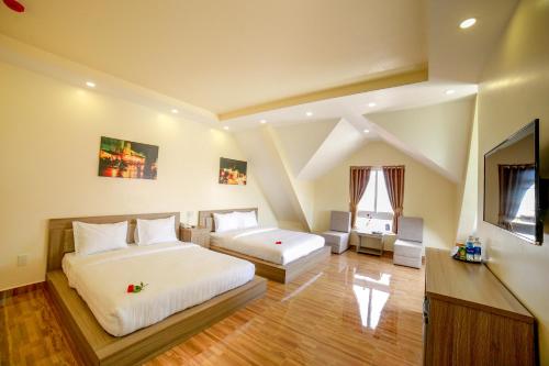 um quarto grande com 2 camas e uma janela em Nhật Nguyên Hotel em Da Lat