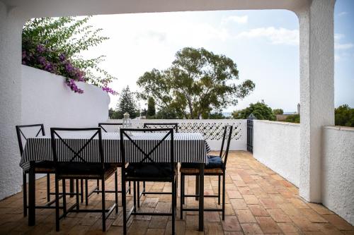 a dining room table and chairs on a patio at Beach House at Praia da Luz in Luz