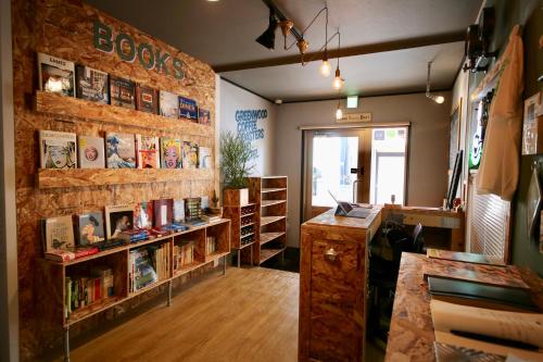 una habitación con estanterías y estanterías con libros en Greenwood Hostel en Izumi-Sano