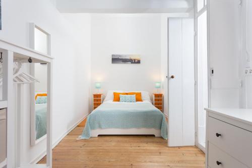 1 dormitorio con 1 cama en una habitación blanca en Crilu, en Lisboa