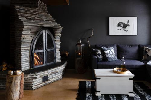 a living room with a couch and a fireplace at Lodge 67°N Lapland in Äkäslompolo