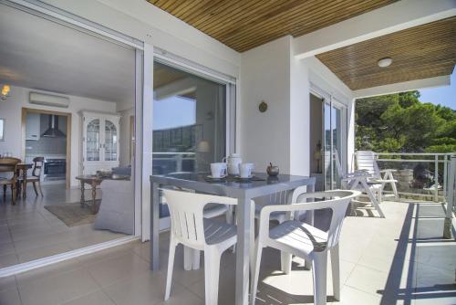 a porch with a table and chairs on a patio at Villas Guzman - Apartamento Bellissimo in Moraira