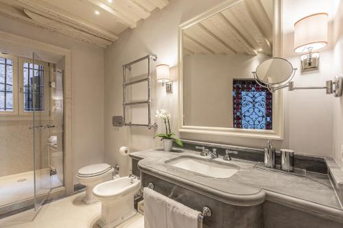 bagno con lavandino, servizi igienici e specchio di La Dimora di San Maurizio 1- Dimora Italia - a Venezia
