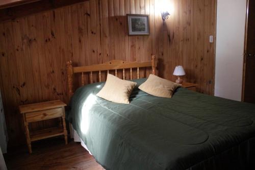 um quarto com uma cama com um edredão verde em KALENA 4 Playa Bonita DAT em San Carlos de Bariloche