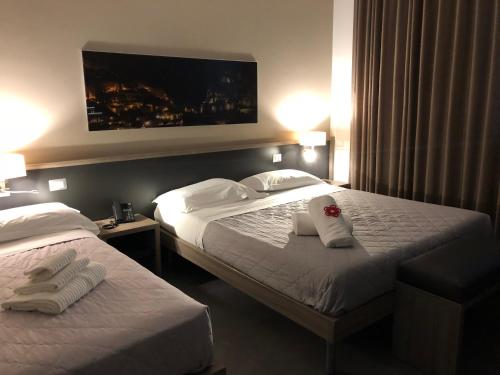 una camera d'albergo con due letti e asciugamani di La Sosta Motel Tavola Calda a Matera