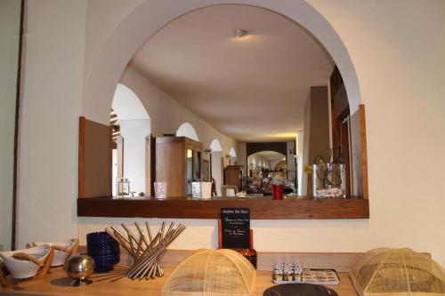 an archway in a room with a table with a mirror at Bergerie du Château - Lacapelle Marival in Lacapelle-Marival