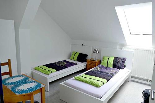 NittenauにあるAngeln am Regen - Angelhof Poslのベッド2台、テーブル、椅子が備わる客室です。