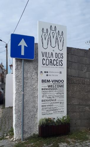 a blue sign next to a wall with a sign for a dog corps at Villa dos Corcéis in Esposende