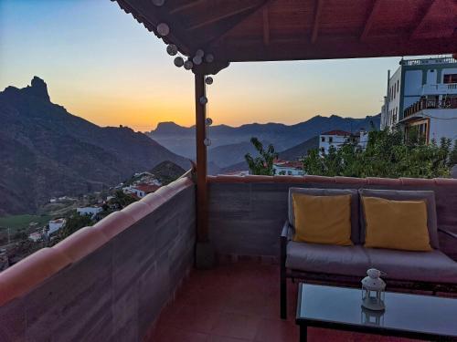 a balcony with a couch and a view of the mountains at Vivienda Vacacional La Portada in Tejeda