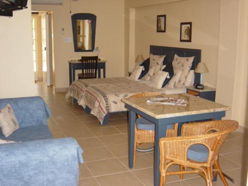 a bedroom with a bed and a table and chairs at Auberge Guest Lodge in Nelspruit