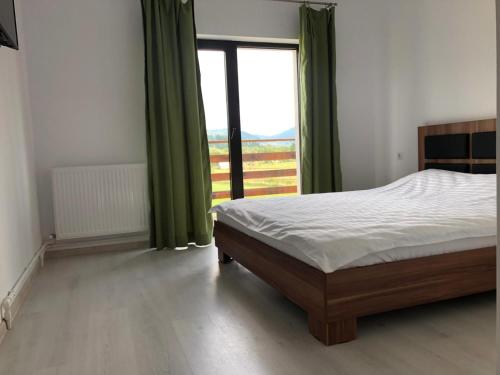 a bedroom with a bed and a large window at Casa EVA in Panaci