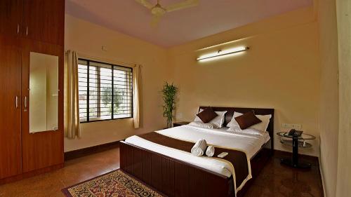 Un dormitorio con una cama grande y una ventana. en Nandu Hospitality Apartments Services - Aashiyana, en Bangalore
