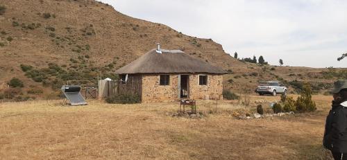 a small stone building with a cross on top of it at Twin Peaks Cottages and Horse Trekking in Maseru