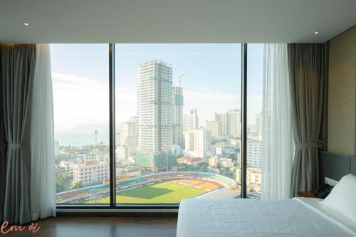 a bedroom with a large window with a view of a city at Em Oi Boutique Hotel in Nha Trang