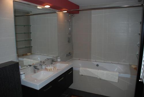 a bathroom with a sink and a tub and a mirror at Apartment OneClickRent 07 Penthouse in Chişinău