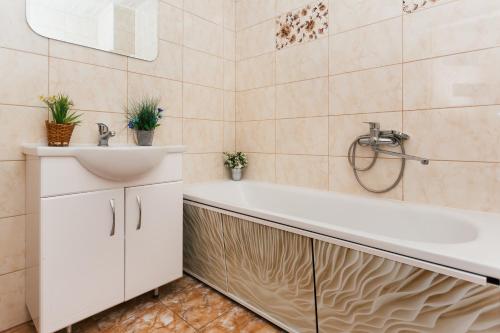 a bathroom with a white tub and a sink at Luxury apart-hotel on Kharkovskaya New Building 6 floor in Sumy
