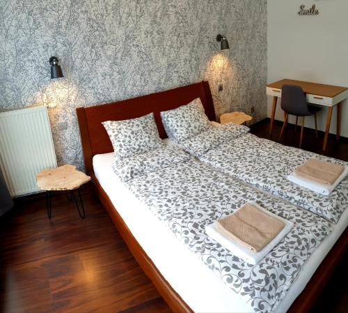 a bedroom with a large bed with white sheets and a desk at Apartament NAD MALTĄ in Poznań